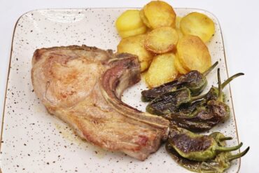 chuletón de cerdo con su guarnición principal