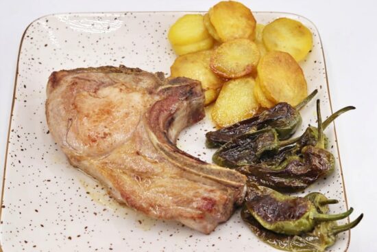 chuletón de cerdo con su guarnición principal